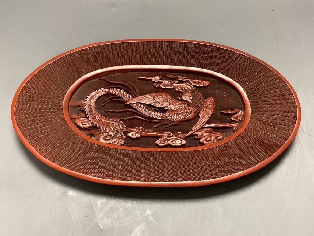 A Chinese lacquer and composition dish and a bronze hand warmer, length 27cm